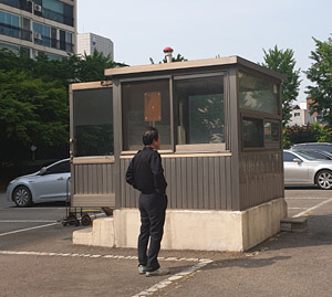 경비원 이모(64) 씨가 지난 14일 서울 송파구 한 아파트에서 자신이 근무하는 알루미늄 부스 경비실을 바라보고 있다.
