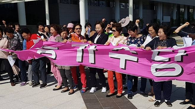 여성농민 30여명이 21일 전남도청 앞에서 ‘농가수당’이라고 쓴 펼침막을 찢으며 “농민수당을 모든 농민에게 지급하라”고 촉구하고 있다.