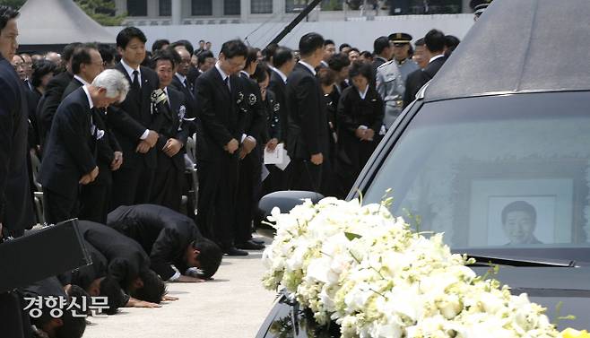 고 노무현 대통령의 영결식이 열린 경복궁에서 노제를 위해 광화문으로 이동하는 영구차를 향해 참여정부 참모들이 절을 하며 배웅하고 있다. 바닥에 엎드린 맨 오른쪽 사람이 유시민 노무현재단 이사장이다.  2009.5.29ⓒ 장철영