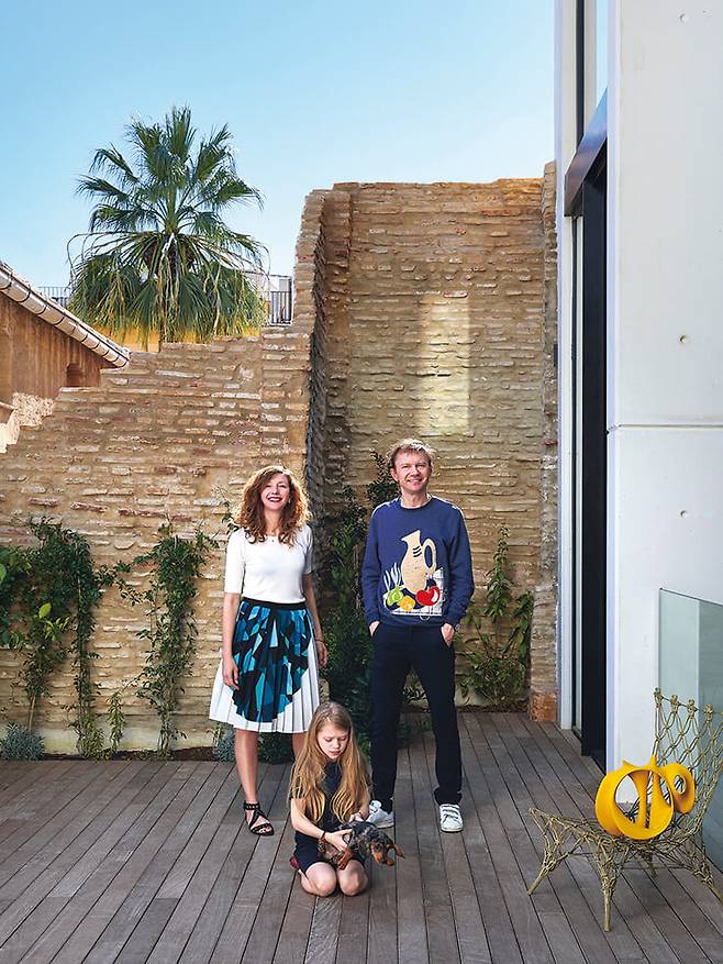 테라스에 선 가족. 딸 엘로이즈가 반려견 말론과 놀고 있다. 모라이마가 입은 스커트는 마티외에게 상당한 영감을 받았다고 말하는 패션 디자이너 크리스틴 풍(Christine Phung)의 작품. 그물처럼 생긴 의자는 마르셀 반더스가 디자인한 ‘노티드 체어’로 Cappellini. 그 위에 올려진 세라믹 오브제는 체칠레 몰리나(Cecile Molina)의 작품이다.