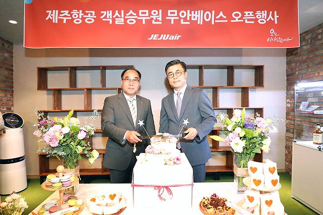 지난 23일 오후 무안국제공항 제주항공 승무원라운지에서 정상국(왼쪽) 한국공항공사 무안지사장과 김용태 제주항공 객실본부장이 무안베이스 오픈 축하케이크를 자르고 있다. [제주항공 제공]