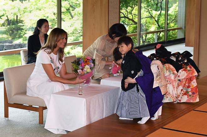 두 사람이 공연을 마친 어린아이들에게 꽃다발을 받고 있다. [AP=연합뉴스]