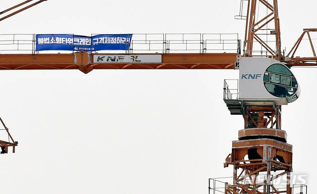 【경산=뉴시스】우종록 기자 = 타워크레인 건설노조가 총파업에 들어간 4일 오후 경북 경산시 중산동 한 아파트 공사 현장에서 소형 무인 타워크레인 철폐를 요구하는 노동자의 점거로 크레인이 가동을 멈춘 채 서 있다. 2019.06.04.wjr@newsis.com