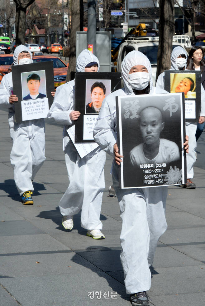 반올림 회원들이 지난 2014년 고 황유미 사망 7주기를 맞아 전자산업 피해 노동자들의 사진을 들고 행진하고 있다./김창길 기자