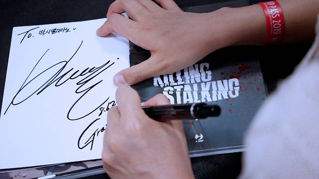 쿠기 작가가 한 이탈리아 팬에게 사인을 해주고 있다. (사진=레진엔터테인먼트)