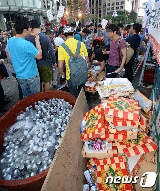 일간베스트저장소(일베) 회원들과 자유청년연합 회원들이 2014년 9월 광화문 단식농성장 인근인 동아일보 사옥 앞에서 치킨과 피자를 먹는 '폭식 퍼포먼스'를 하고 있다. [뉴스1]