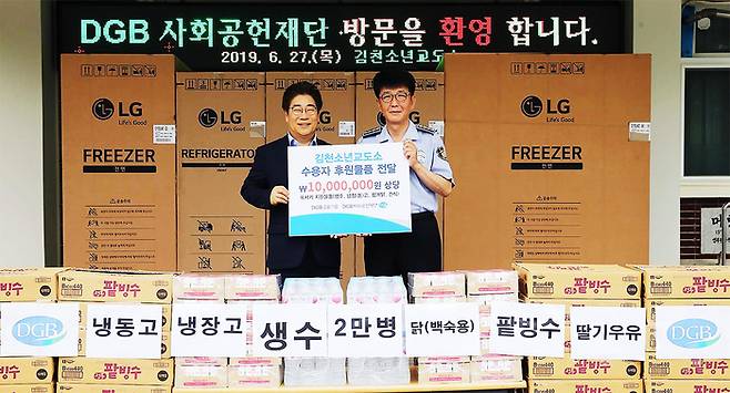 이용한 DGB금융그룹 상무가 27일 이동희 김천소년교도소장에게 수용자들을 위한 간식과 물품을 전달하고 있다. DGB금융그룹 제공.