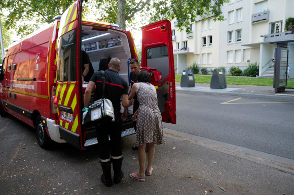 27일 프랑스 중부 투르에서 소방관들이 더위에 따른 고통을 호소하는 시민을 후송하고 있다. 투르/AFP 연합뉴스