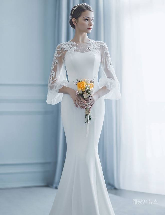 사진 : 단정한 도비실크 머메이드 드레스. 슬리브리스를 감싸는 하늘하늘한 형태의 소매가 고풍스러운 우아함을 놓치지 않는다. 펠리스노비아
