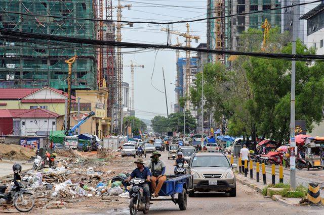 시아누크빌 시내 풍경. 중국 자본에 의한 호텔, 카지노, 아파트 공사가 한창이다. 공사장에서 나온 쓰레기, 움푹 패인 도로의 물을 피해 자동차와 오토바이들이 위태롭게 달리고 있다.