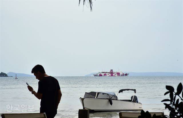 시아누크빌에는 중국 자본의 카지노가 급속도로 늘고 있다. 2016년 당시 13개에 불과했던 카지노 수는 현재 공사중인 것들을 포함, 110개가 넘는다고 한다. 심지어 크루즈선을 이용한 바다위의 카지노도 개업을 앞두고 있다. 한 중국 관광객이 정박중인 크루즈 카지노가 보이는 해안에서 휴대폰을 사용하고 있다.