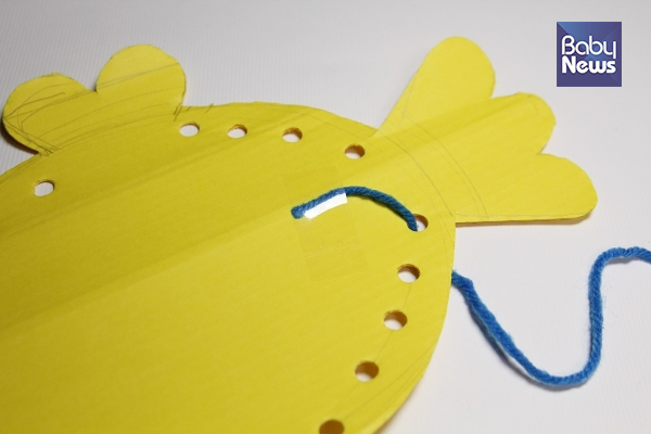 털실의 한 쪽 끝을 테이프로 뒷 면에 고정시켜주세요. ⓒ허진