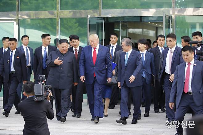 김정은 북한 국무위원장이 6월 30일 판문점 남측 자유의집에서 도널드 트럼프 미국 대통령과 회동을 마친 뒤 문재인 대통령 등과 함께 군사분계선으로 이동하고 있다. 김기남 기자