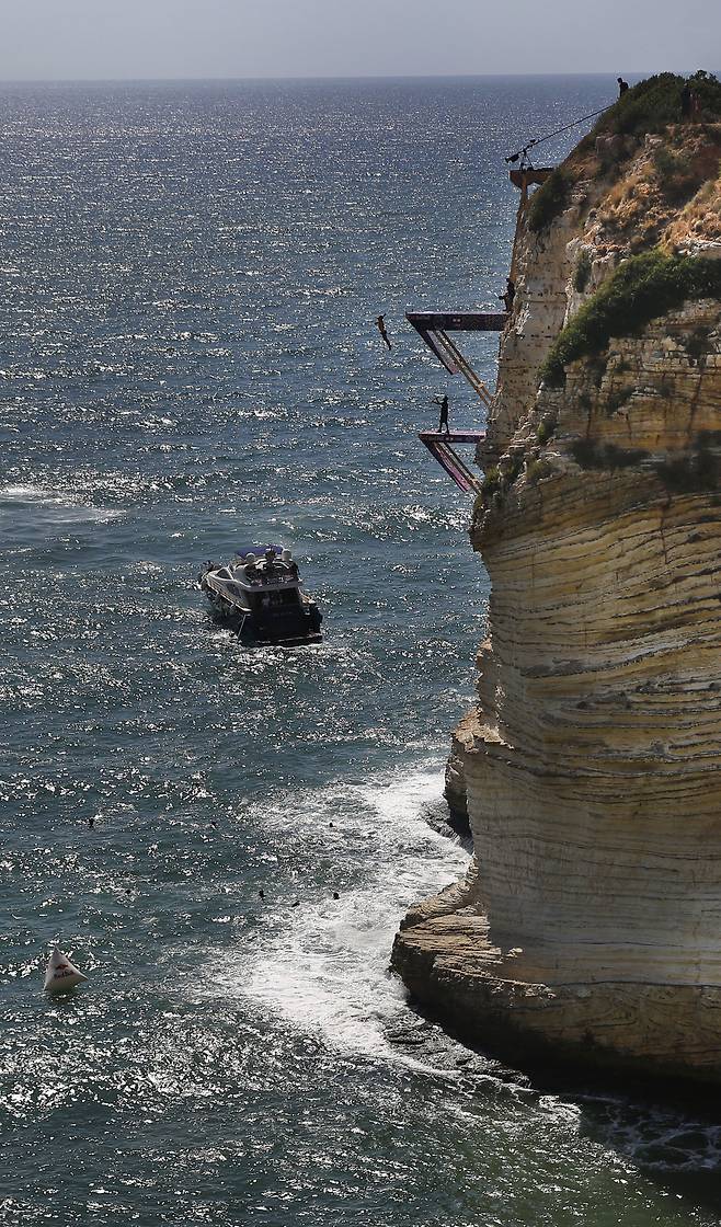 14일(현지시간) 깍아지른 듯한 절벽위에서 선수들이 아찔한 점프를 선보이고 있다. [AP=연합뉴스]