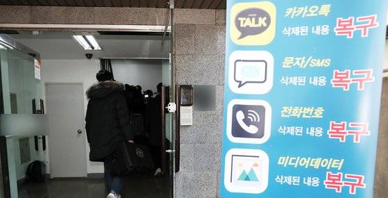 불법촬영물 유포 혐의를 받고 있는 가수 정준영씨가 과거 휴대폰 수리를 맡겼던 사설 수리업체에 대해 압수수색을 진행 중인 경찰이 13일 오후 서울 강남구 휴대폰 사설수리업체로 가방을 들고 들어가고 있다. 2019.3.13/뉴스1