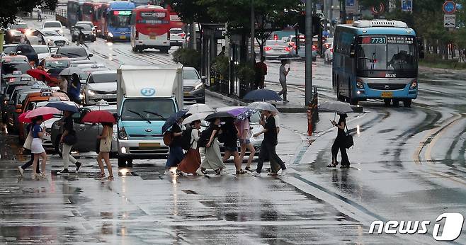 장마전선의 영향으로 전국이 흐리고 곳곳에 비가 내리는 28일 서울 마포구 동교동 삼거리에서 시민들이 우산을 쓰고 발걸음을 재촉하고 있다. 2019.7.28/뉴스1 © News1 이승배 기자