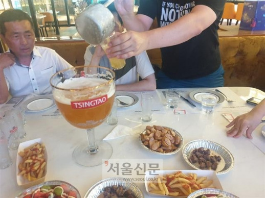 칭다오 시내 칭다오맥주 직영 펍에서 주문한 4리터 대용량 맥주. 맥주를 국자로 퍼서 마셔야 한다.