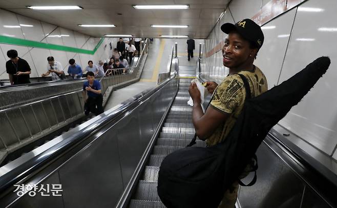 아미두가 에스컬레이트를 타고 지하철 승강장으로 이동하고 있다.