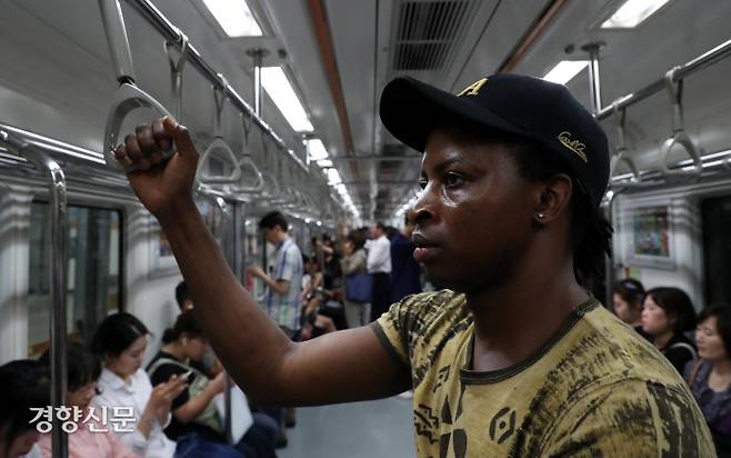 아미두가 지하철을 타고 집으로 향하고 있다. 그는 지하철에서 절대 자리에 앉지 않는다.