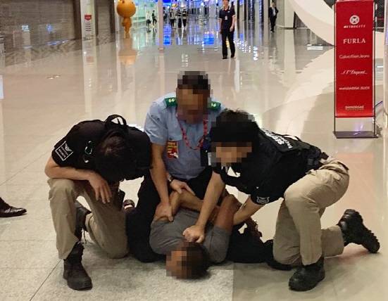보안업체 직원들이 7월26일 인천공항 제2여객터미널 출국장 3층에서 불법 입국을 시도한 외국인을 붙잡아 제압하고 있다. (사진 = 독자 제공)