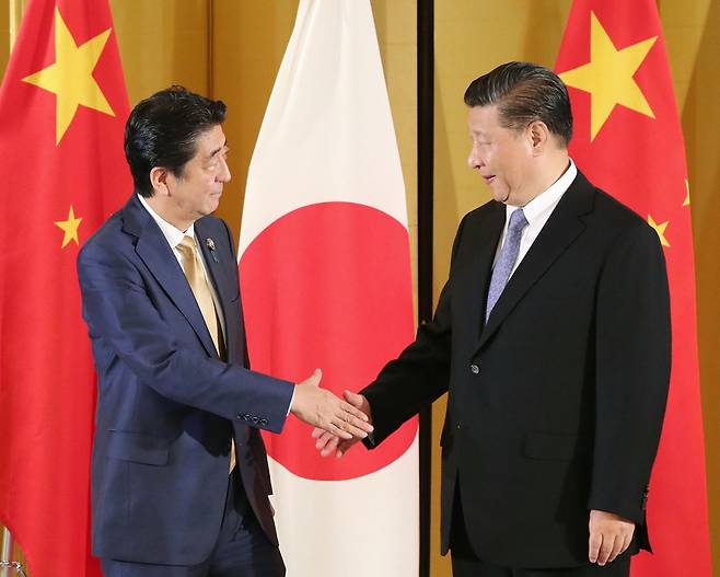 아베 신조 일본 총리(왼쪽)와 시진핑 중국 국가주석이 6월27일 일본 오사카의 한 호텔에서 정상회담을 하면서 악수를 나누고 있다. 오사카/교도 연합뉴스
