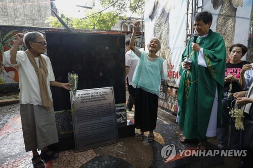 필리핀 성당 내 세워진 '일본군 성노예' 추모비와 생존자 에스텔리타 디 할머니(왼쪽)와 나르시사 클라베리아 할머니(오른쪽) [EPA=연합뉴스]