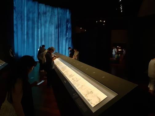 전시 ‘우리 강산을 그리다’ 2부 전시장. 안쪽 폭포가 쏟아져내리는 동영상 스크린을 배경으로 18세기 말 거장 김홍도가 그린 길이 16m짜리 금강산사생첩을 관객들이 관람하고 있다.