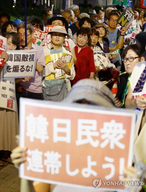 '한일민중 연대하자' (도쿄 교도=연합뉴스) 지난 19일 오후 도쿄 나가다초 국회의사당 인근에서 열린 아베 정권 규탄 집회에서 한 참가자가 '한일민중 연대하자'라고 적힌 손팻말을 들어 보이고 있다. photo@yna.co.kr