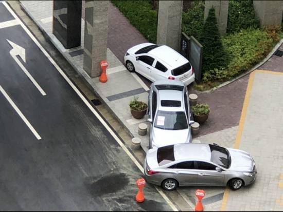 아파트 지하주차장 진입로를 가로막은 차량을 입주민들이 인도로 옮겨 놓은 모습. 온라인커뮤니티 캡처