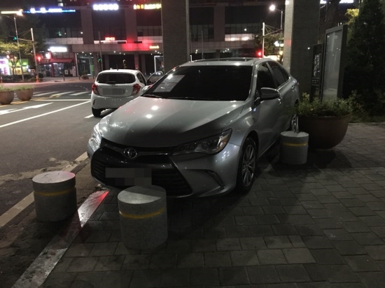 아파트 지하주차장 진입로를 가로막은 차량을 입주민들이 인도로 옮겨 놓은 모습. 독자 제공