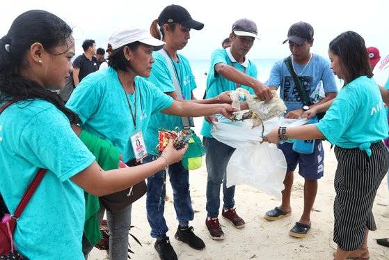 에어서울 승무원들과 현지직원, 주민들이 해변으로 떠내려온 쓰레기들을 수거하고 있다. 장진영 기자