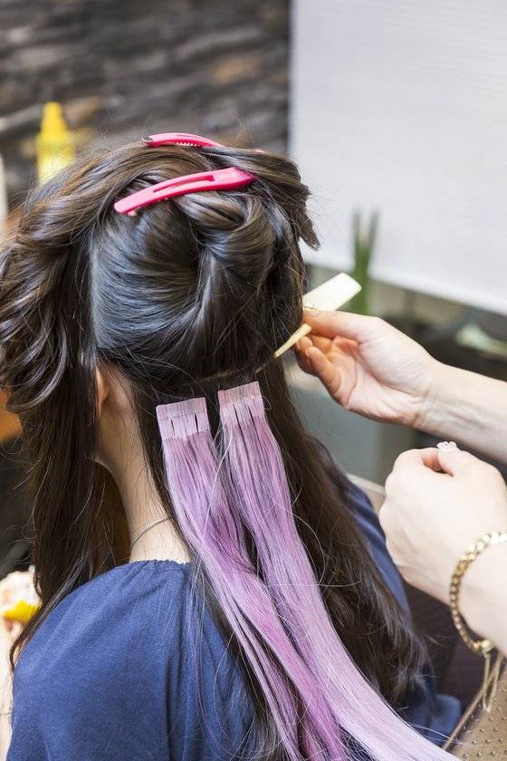 포인트 붙임머리를 위해 컬러피스를 머리카락 밑과 위에 붙여주고 있다.