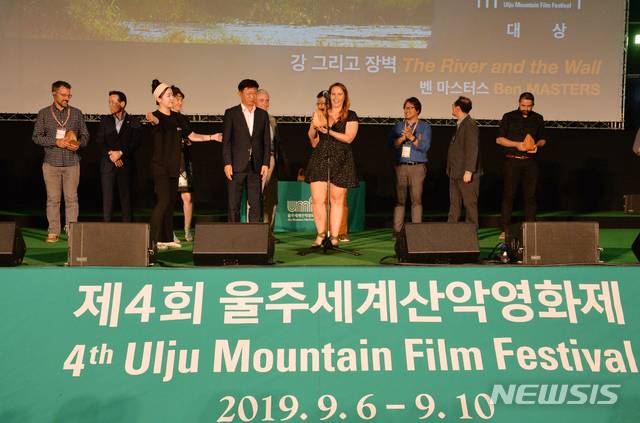【울산=뉴시스】배병수 기자 = '함께 가는 길'이란 주제로 열린 제4회 울주세계산악영화제  폐막식이 10일 울주군 상북면 등억알프스리 복합웰컴센터 움프시네마에서 벤마스터스 미국 감독의 '강, 그리고 장벽' 이 산악영화제 대상을 수상한 가운데 힐러리 피어스 프로듀스가 대리수상하고 있다. 2019.09.10. bbs@newsis.com