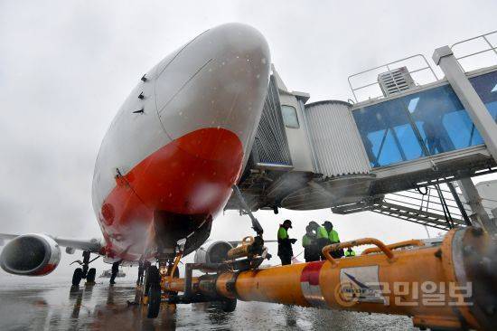 업무를 마친 조업사 직원들이 비행기가 관제 신호를 기다리며 브릿지 밑에서 비를 피하고 있다.