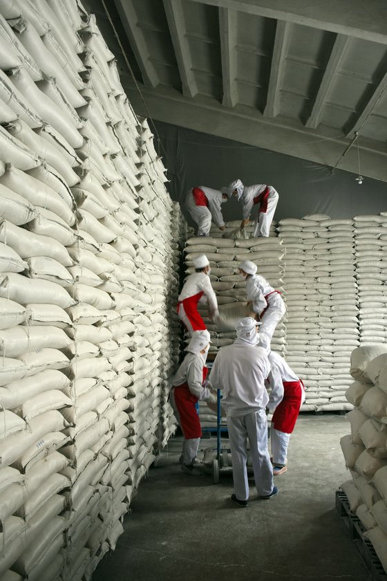 지난 2016년 북한의 한 WFP 지원 공장에서 직원들이 식량을 쌓는 모습. [WFP 제공]