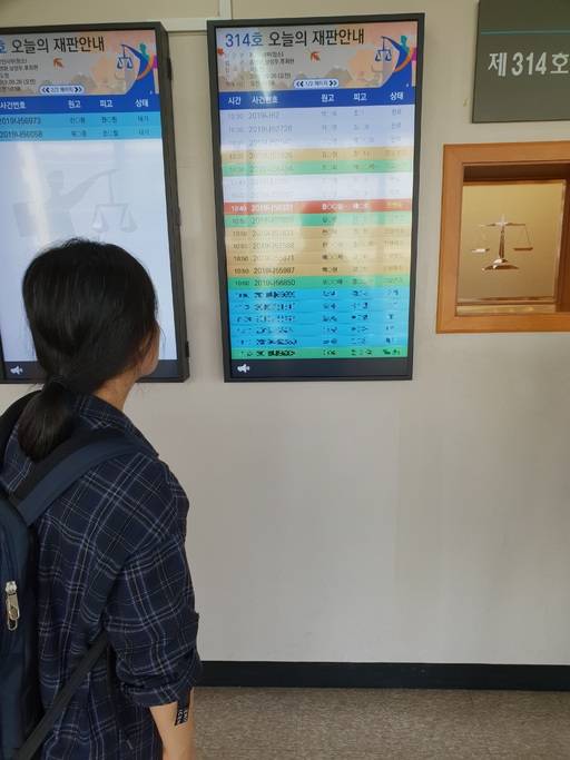 항소심 첫 재판이던 26일 어머니 A씨가 법정에 붙은 재판 안내판을 바라보고 있다. 이창수 기자