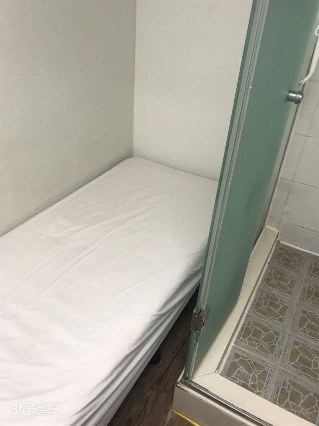 이보라(가명)씨가 사는 서울 마포구 고시원 방에는 수평이 맞지 않은 침대 바로 옆에 유리벽 샤워실이 붙어있다. 이보라씨 제공