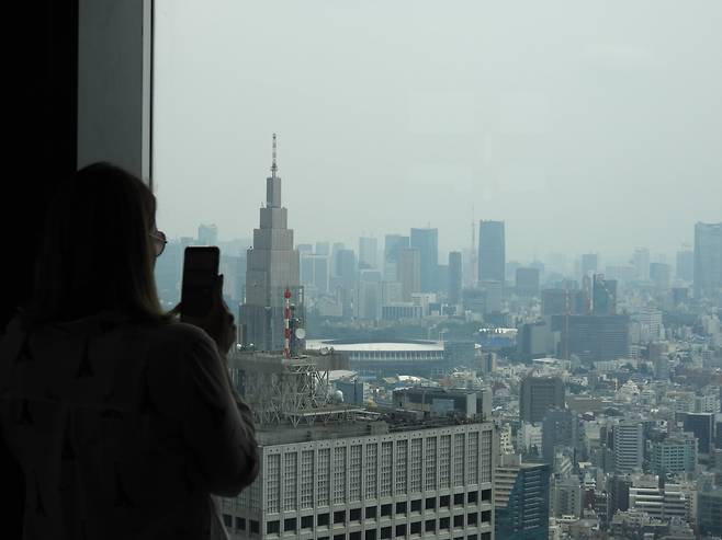 도쿄도청 45층 전망대에서 외국인 관광객이 도쿄 시내를 휴대폰으로 촬영하고 있다. 강찬수 기자