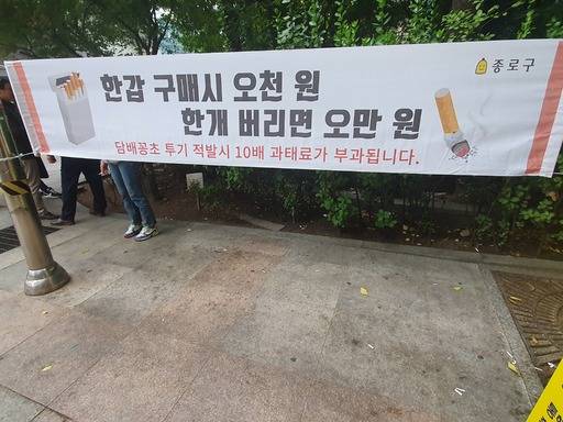 서울시 종로구의 한 빌딩가에 담배꽁초 무단투기를 경고하는 현수막이 걸려있다. 하지만 바닥에는 담배꽁초가 버려져 있다.