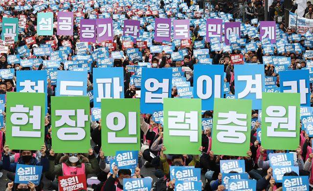 철도노조 파업 나흘째인 23일 오후 서울 종로구 우정국로에서 열린 공공운수노조 결의대회에서 참가자들이 피켓을 들고 구호를 외치고 있다.  이들은 현장 인력 충원, 임금피크제 폐지 등을 촉구했다. 연합뉴스