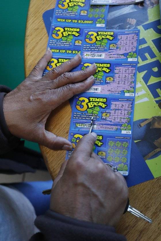 미시시피주 시민들이 25일 복권 판매소에서 즉석복권을 구입해 당첨을 확인하고 있다. [AP=연합뉴스]