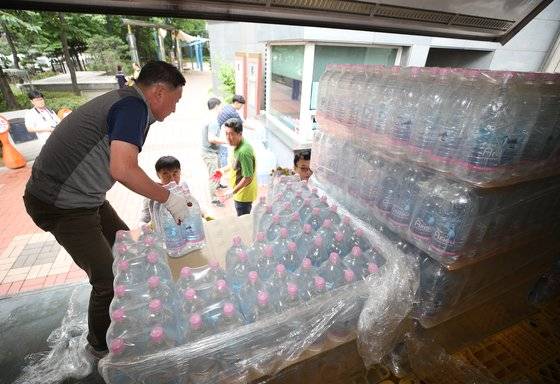 지난 6월 21일 오후 붉은 수돗물이 나온 서울 영등포구 문래동의 한 아파트에서 서울시 직원들이 아리수를 옮기고 있다.[뉴스1]
