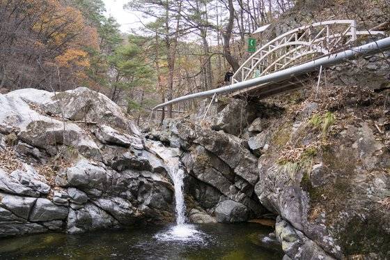 응봉산 원탕으로 가는 길. 덕구계곡으로 들면 크고 작은 폭포와 다리가 잇따라 나온다. 다리 옆으로 온천수가 흐르는 송수관 파이프가 보인다. 백종현 기자