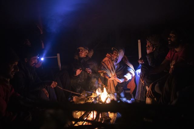보스니아 북서부 비하치 와곽에 있는 부치자크 난민 캠프에서 1일(현지시간)  보스니아 난민들이 텐트안에 마련된 모닥불 앞에 앉아 있다. 혹독한 날씨가 다가왔음에도 불구하고, 수백 명의 난민들과 이주자들은 여전히  국제기구가 위험하고 비인간적이라고 묘사한  보스니아 북서부에 있는  임시 수용소에 갇혀 있다. AP 연합뉴스