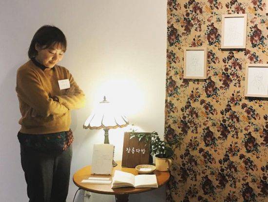 이연우 작가가 성북예술창작터에 전시된 어르신들의 이야기를 듣고 엮어 낸 단행본 '장롱다방' 앞에서 포즈를 취하고 있다. 장롱다방은 노인 이야기 들어주는 청년 예술가 프로젝트를 통해 만들어진 책이다. 이 작가 친할머니의 인생 보물상자였던 '장롱'을 컨셉으로 잡았다. 그는 "장롱이란 소재가 없이도 단순히 이야기를 듣는 행위만으로도 어르신들의 친구가 돼 인생 얘기를 들을 수 있었다"고 말했다. (제공=이연우 작가)