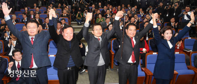 자유한국당 심재철 신임 원내대표(왼쪽에서 네번째)와 김재원 정책위의장(두번째)이 9일 의원총회에서 황교안 대표, 나경원 전 원내대표 등과 함께 손을 들어 인사하고 있다. 권호욱 선임기자 biggun@kyunghyang.com