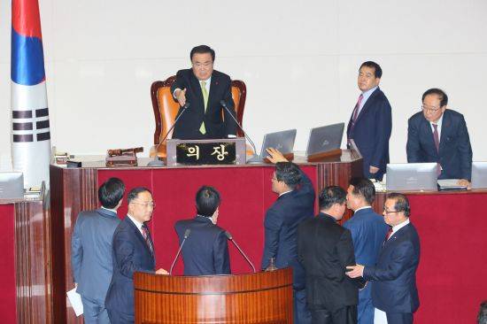 홍남기 경제부총리가 10일 국회 본회의에서 자유한국당 의원들이 예산안 상정에 대해 문희상 의장에게 항의하는 동안 정부측 답변을 위해 단상으로 향하고 있다.  연합뉴스