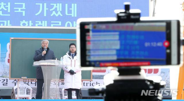 [서울=뉴시스]박미소 기자 = 지난 8일 오전 서울 종로구 광화문 교보빌딩 앞에서 문재인하야범국민투쟁본부 주최로 열린 '대한민국 바로세우기 국민대회'에서 전광훈 목사가 설교하는 모습을 한 유투버가 생중계하고 있다. 2019.12.08.  misocamera@newsis.com