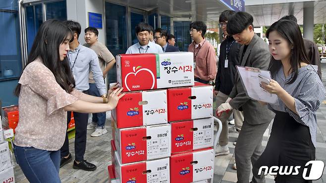 전북 장수군청 공무원들이 가격 하락으로 어려움을 겪는 농가들을 위해 사과를 구입하고 있다.(장수군제공) /뉴스1