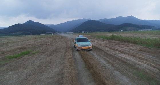 영화 '백두산'에서 화산 폭발로부터 도망치는 자동차 액션 장면이다. 산지가 보이는 지형에서 실제 자동차로 촬영 후 VFX를 입혀 완성했다. [사진 CJ엔터테인먼트·덱스터스튜디오]
